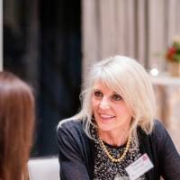 Tammy Huizenga talking with two guests.